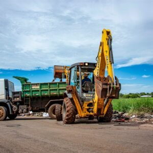 Excavator and truck clearing rubble in Londrina, Brazil outdoors.