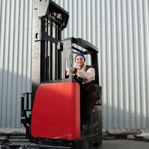 A forklift operator working outdoors in an industrial area with corrugated metal walls.